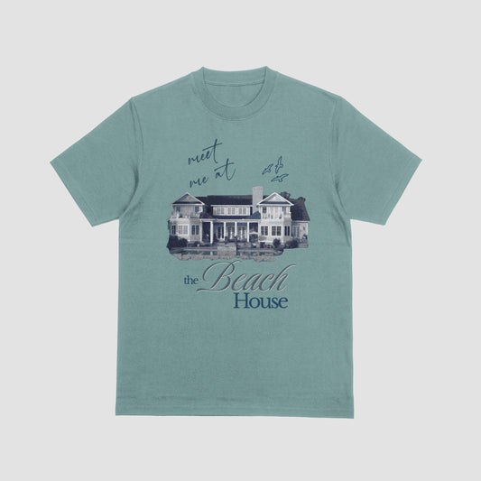 Teal t-shirt with a graphic of a beach house and text on a light gray background