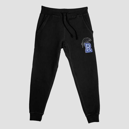 Black sweatpants with a logo on the leg against a light gray background