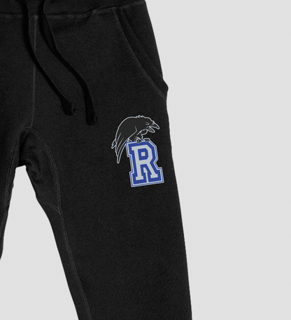 Black sweatpants with a logo on the leg against a light gray background