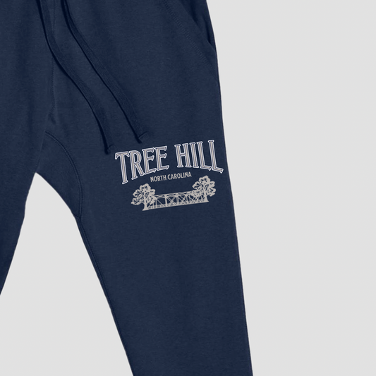 Navy blue sweatpants with 'Tree Hill North Carolina' text and logo on a light gray background