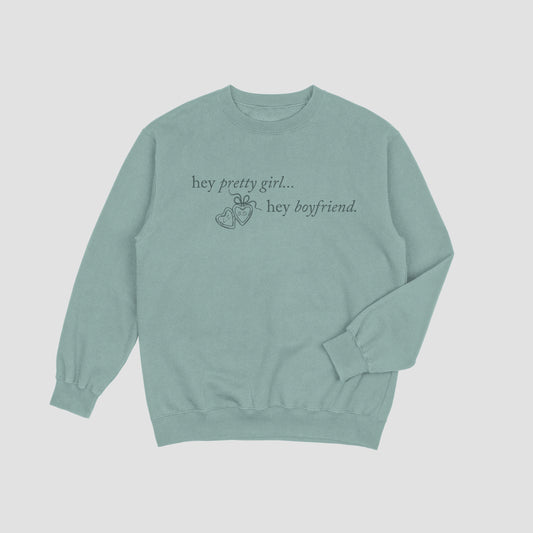 Sage green sweatshirt with text on a light gray background