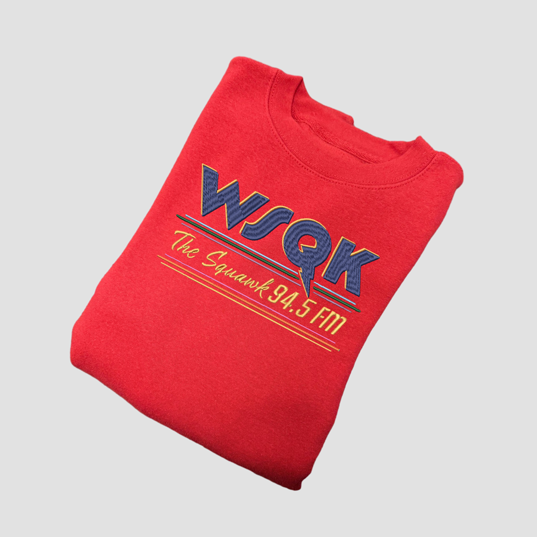 Folded red sweatshirt with 'WSQK' branding on a light gray background